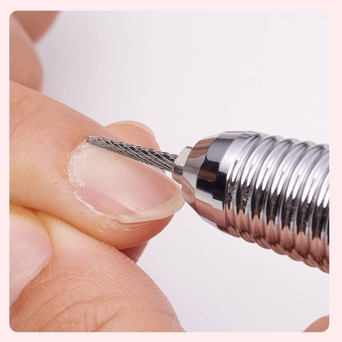 Carbide cuticle nail drill bit working on a fingernail, chrome shaft