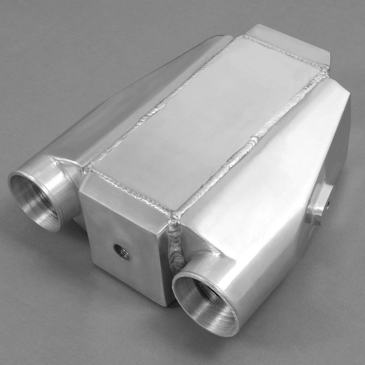Universal air-to-water intercooler side view with two threaded hose fittings and box core