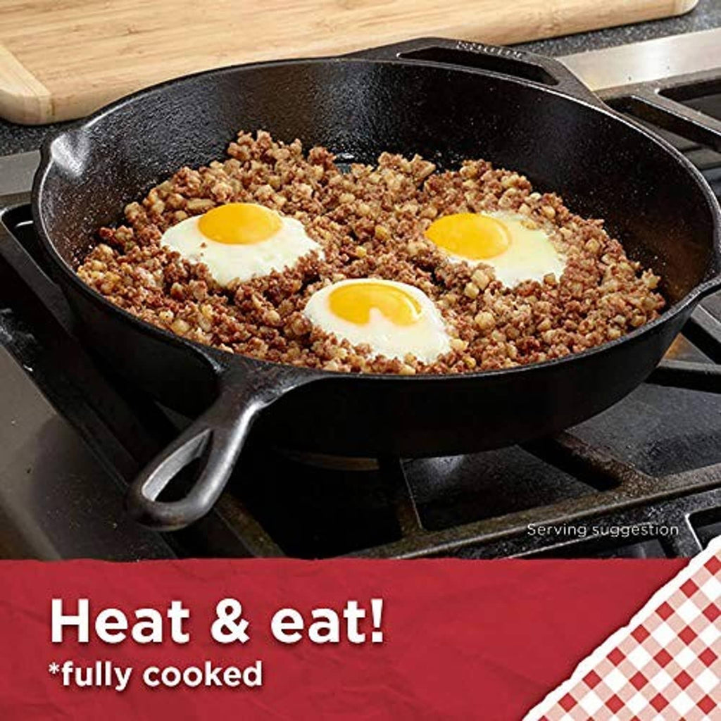 Roast beef hash skillet with three sunny-side eggs in a cast-iron pan