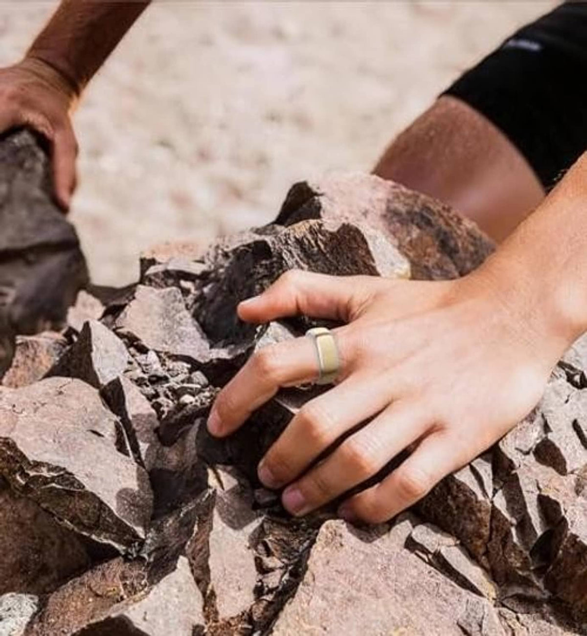 Silver ring cover on finger while handling rocks, slim minimalist band