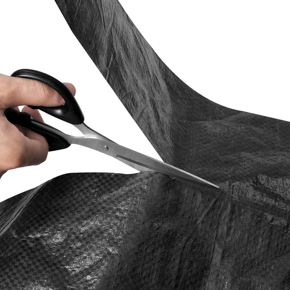Black house wrap sheet being cut with scissors for easy fitting during installation