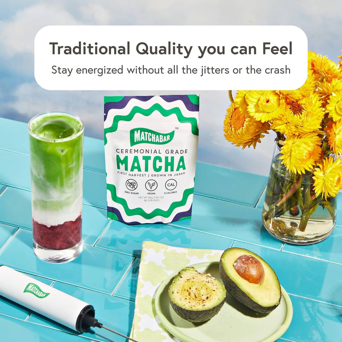 Green matcha drinks with matcha powder bag and cups on a table with flowers
