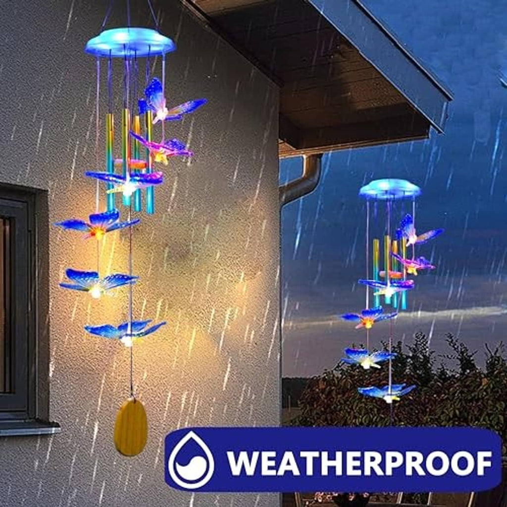 Weatherproof-style blue butterfly solar wind chime glowing in rainy outdoor light