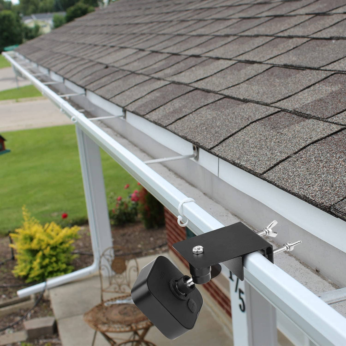 Black gutter mount attached to a white gutter with adjustable bracket