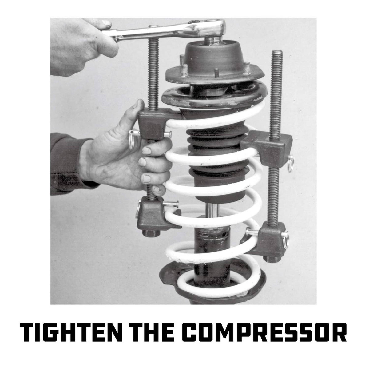 Strut spring compressor kit tightening on a coil spring with threaded adjustment rods