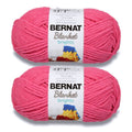 Two skeins of bright pink super-bulky yarn with Bernat Blanket brights labels
