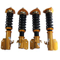 Set of four gold coilover struts with black coil springs and orange adjustment caps