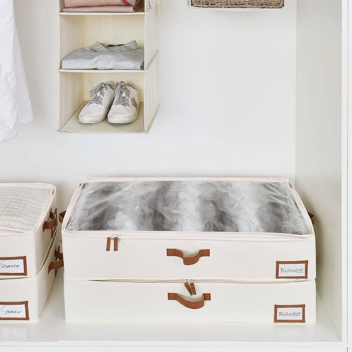Two under-bed storage bins with label windows, white fabric boxes on closet shelf