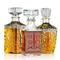 Three-piece crystal whiskey decanter set: clear and amber bottles with faceted sides