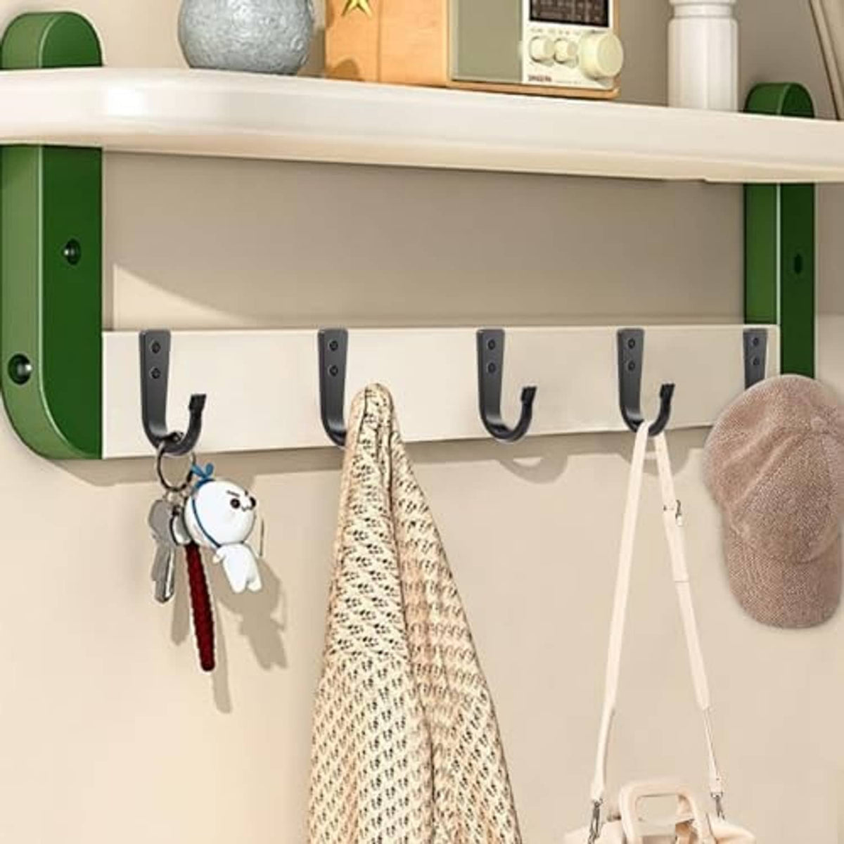 Black wall hooks on a shelf with five U-shaped hangers for hanging accessories