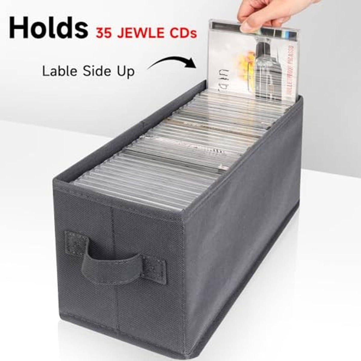 Gray CD storage box with open lid and disc holder pocket, hand placing a CD