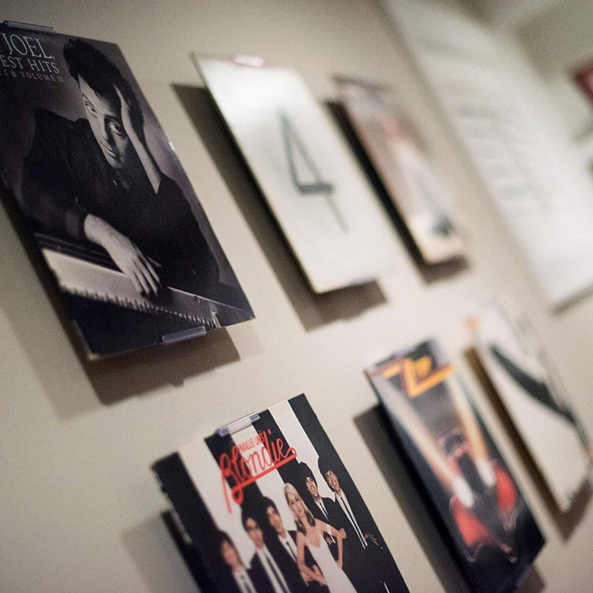Wall-mounted album display frames holding record covers in a grid arrangement
