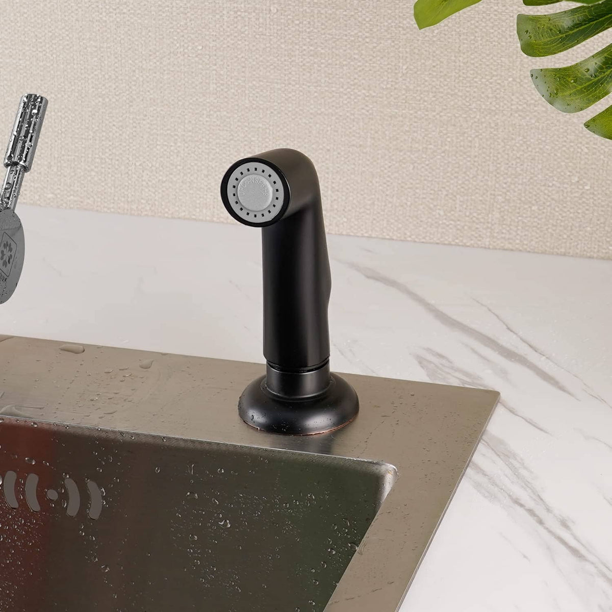 Matte black sink side sprayer head mounted on countertop