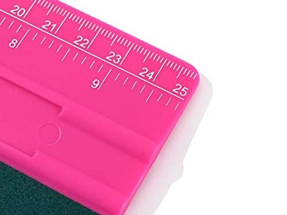 Close-up end of rose pink vinyl squeegee showing 25cm ruler markings