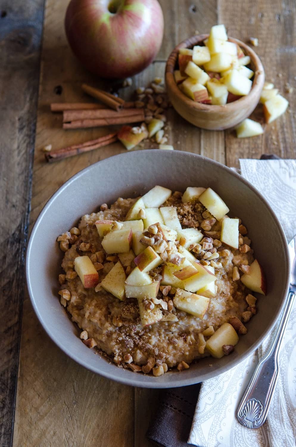 Oatmeal bowl topped with diced apples and chopped nuts