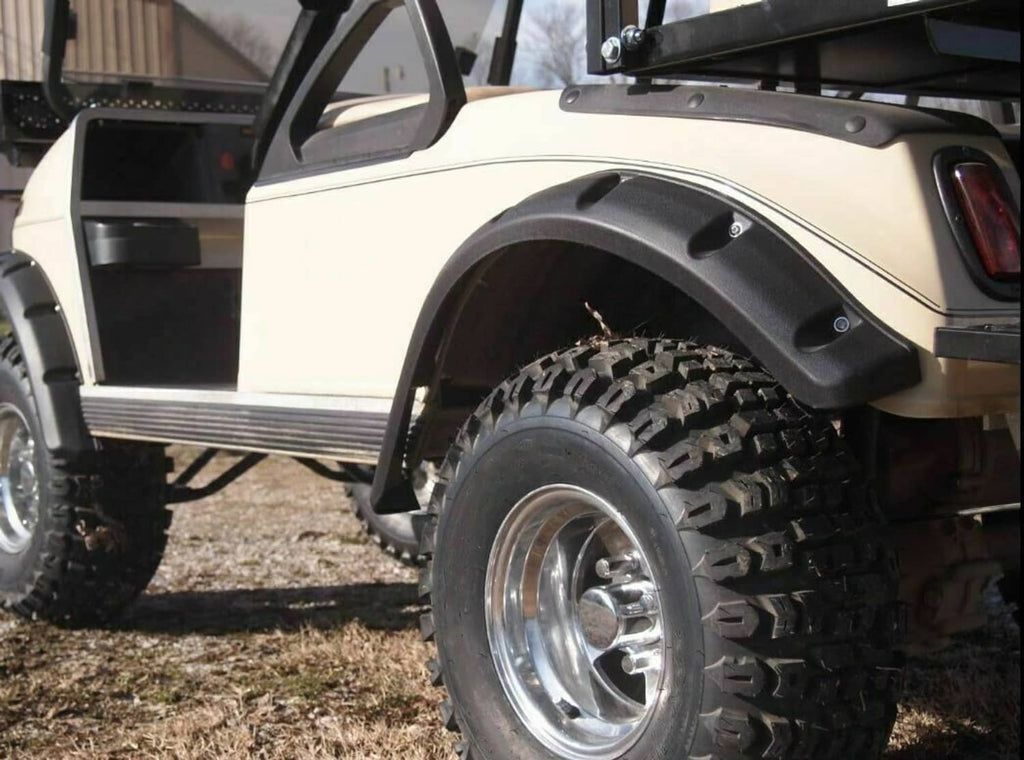 Black fender flare installed over the front tire on a golf cart