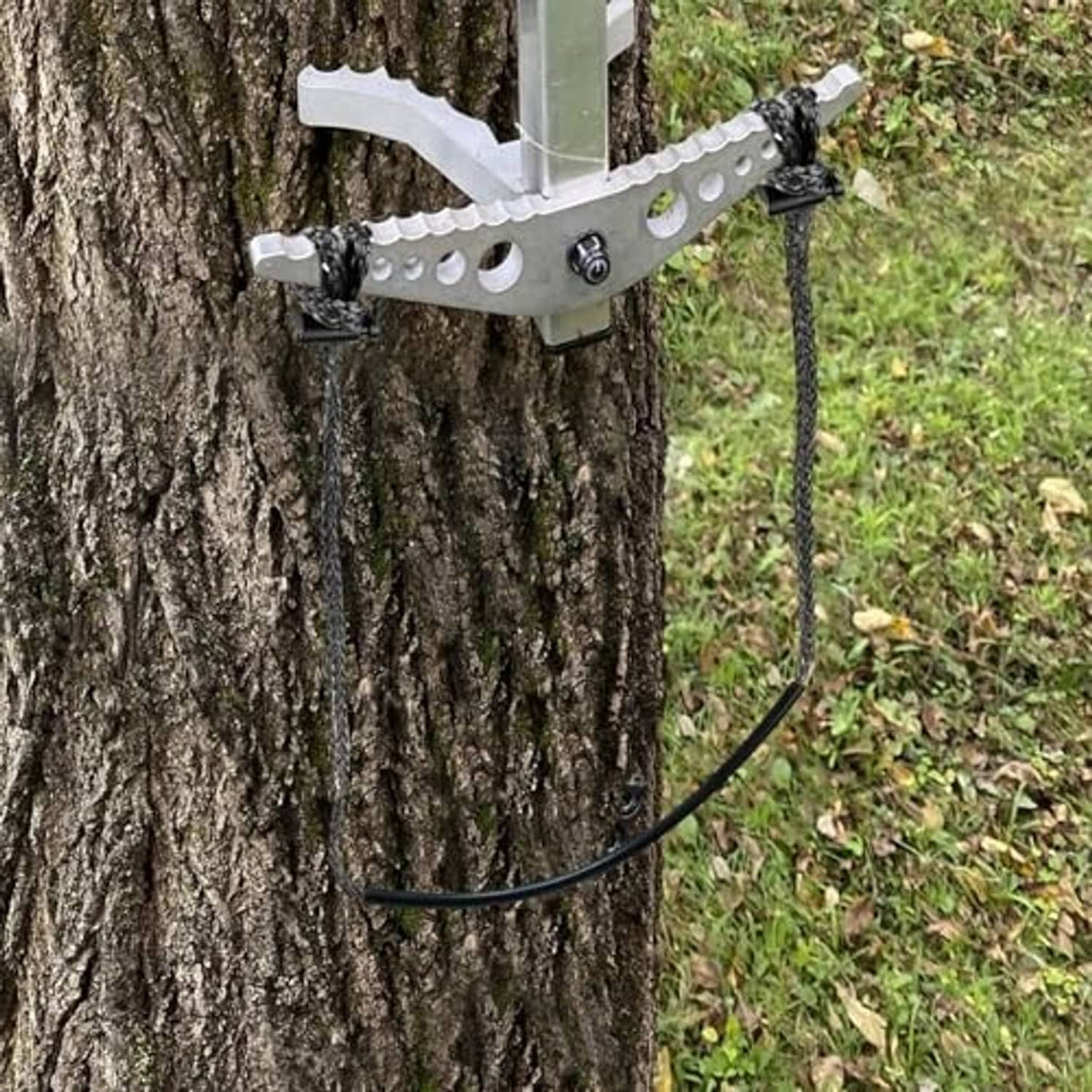 Cable climbing stick aider with metal bracket and curved rope loop on tree