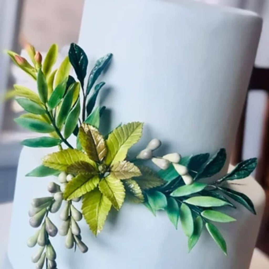 Winter foliage flower topper with green leaves and white berry accents