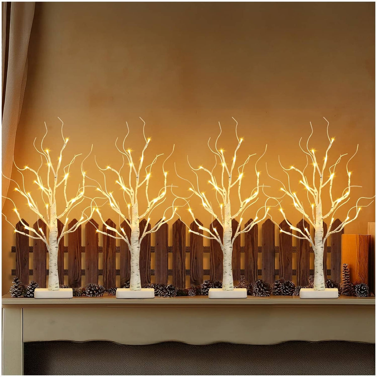 Row of lighted white birch LED trees with warm white lights on square bases
