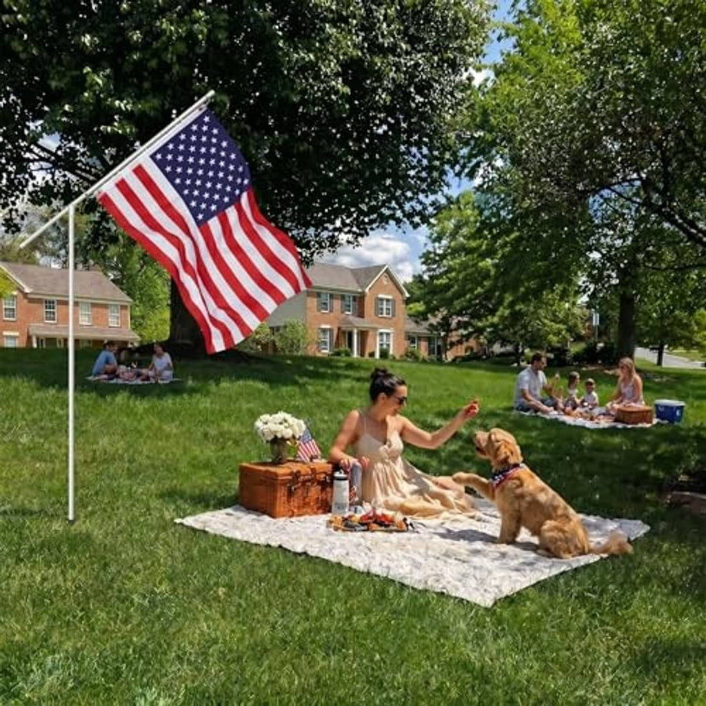 American flag flying on a white telescoping pole with a ground stake
