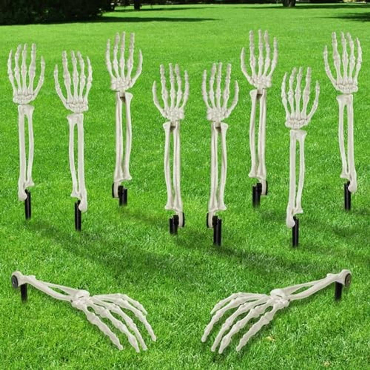 White skeleton hand stakes arranged in rows on a green lawn