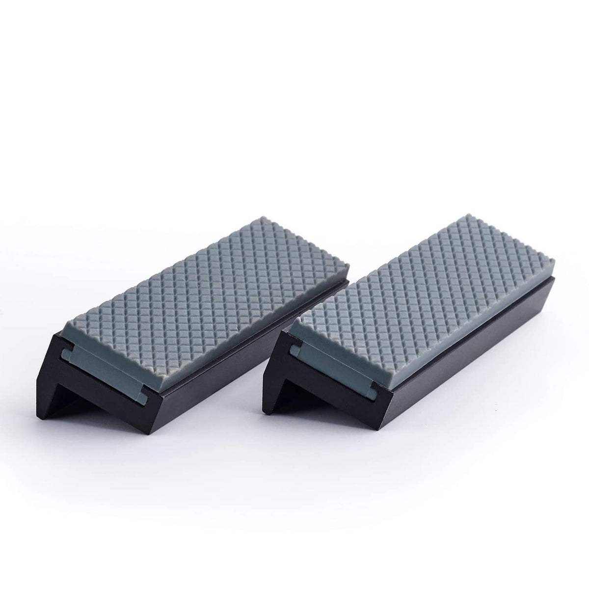 Soft vice jaw pad covers with textured light-gray inserts on dark bases, angled view