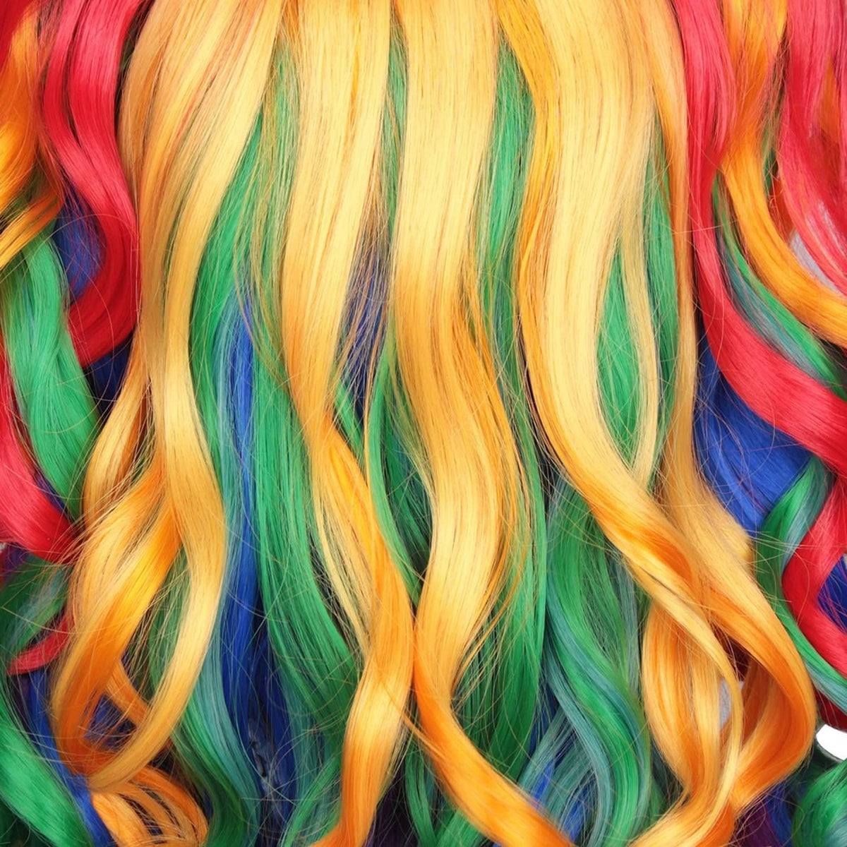 Rainbow curly wig strands close-up, yellow and orange with green and purple tones