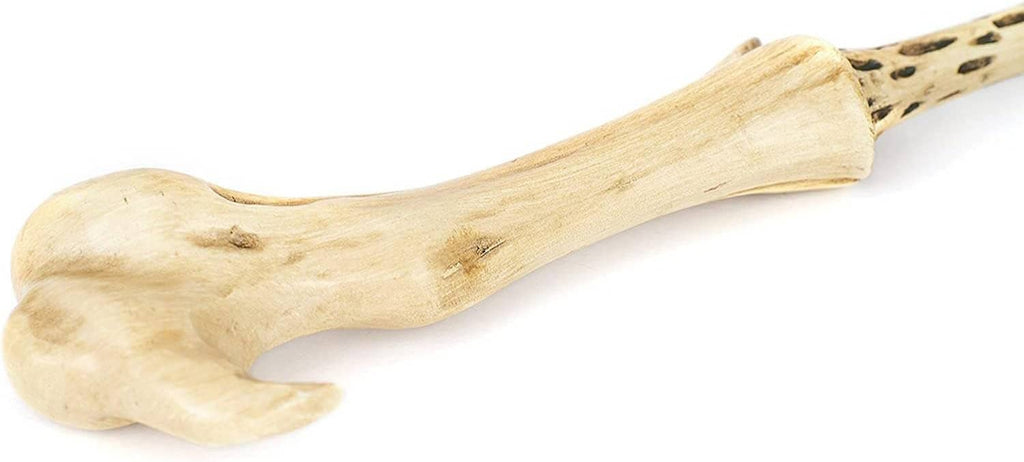 Pale wand grip end with carved knuckles and dark speckled detailing