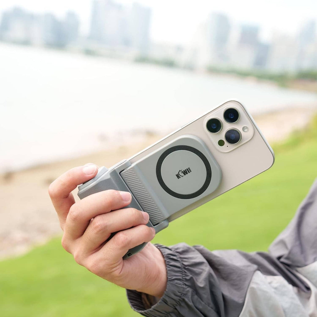 Gray magnetic phone grip attached to smartphone, held in one hand