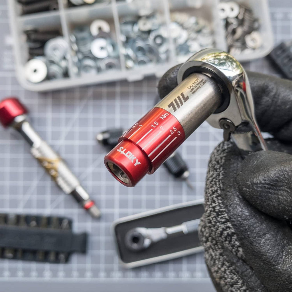 Red mini torque driver socket wrench, showing 0.5–2.5 Nm scale in gloved hand