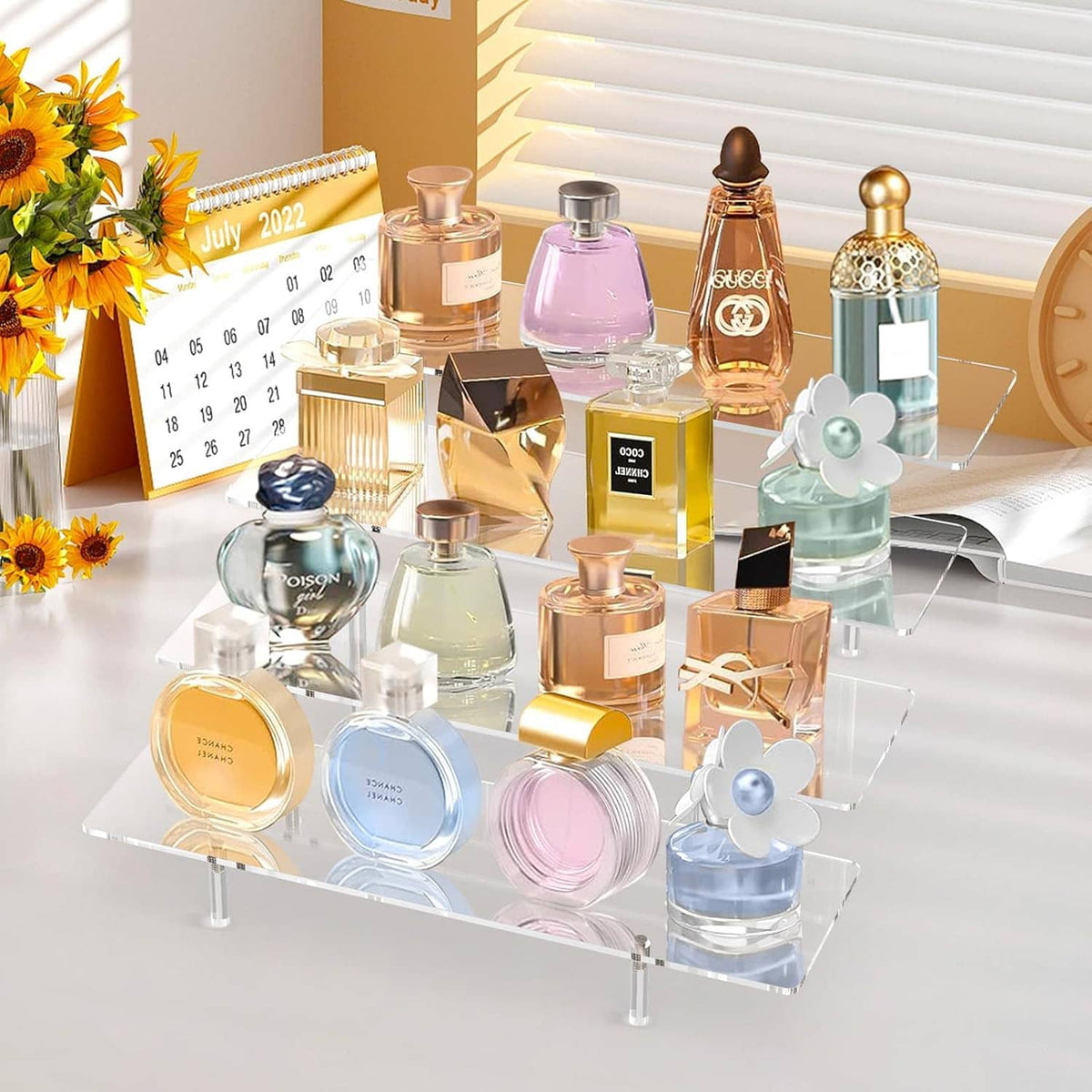 Clear 4-tier acrylic display stand holding perfume bottles and cosmetics