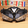Black motorcycle headlight assembly with twin clear lamps and triangular center lens