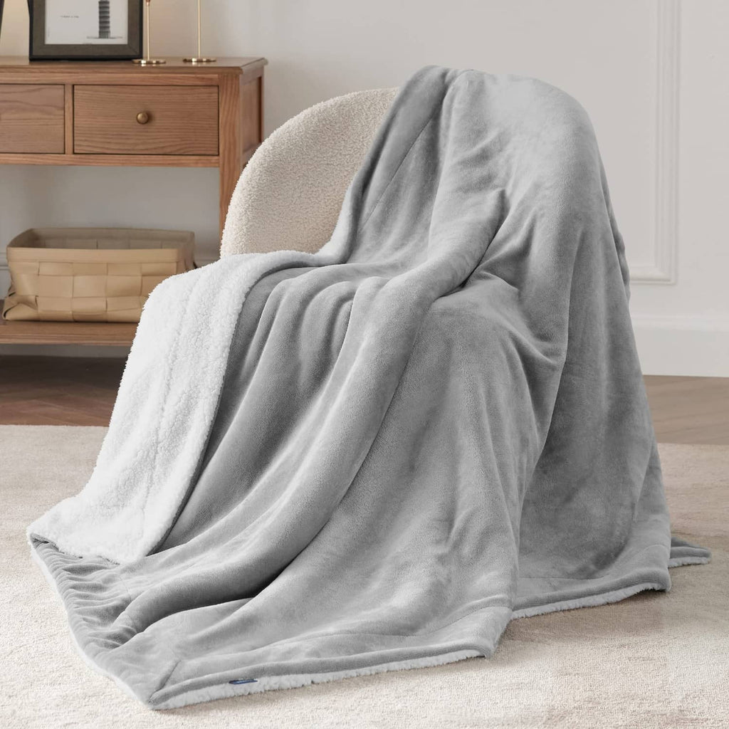 Light grey sherpa fleece throw blanket loosely spread on the floor