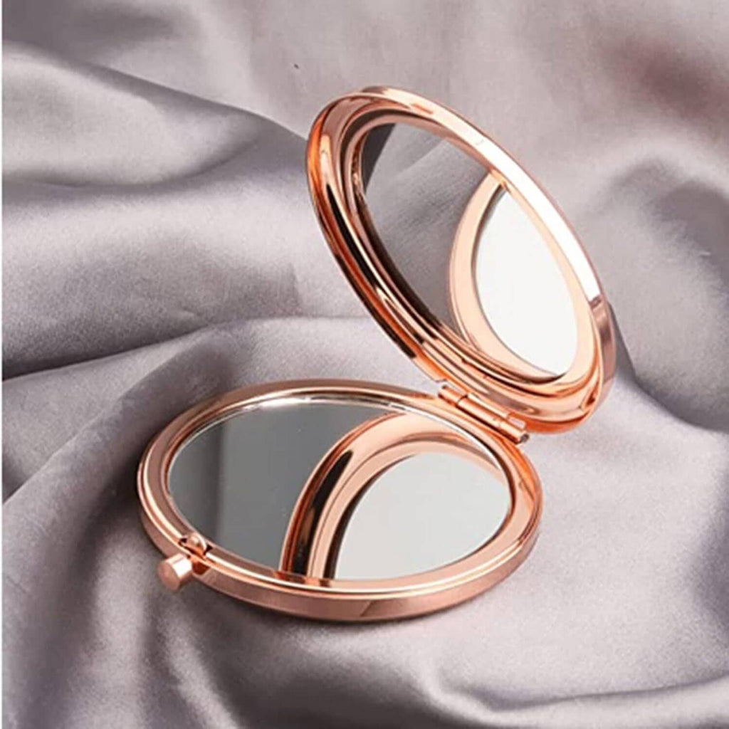 Rose-gold round makeup mirror compact with lid open, showing reflective mirror surface.