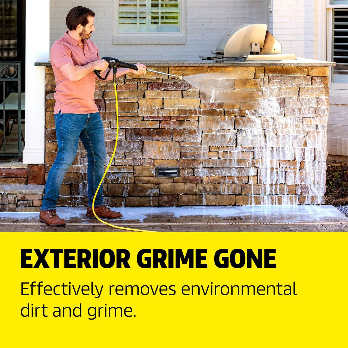 House and siding cleaner use: person pressure-washing brick wall with spray wand