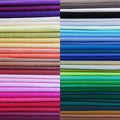 Solid-color cotton fabric squares bundle, neatly stacked in multiple colors