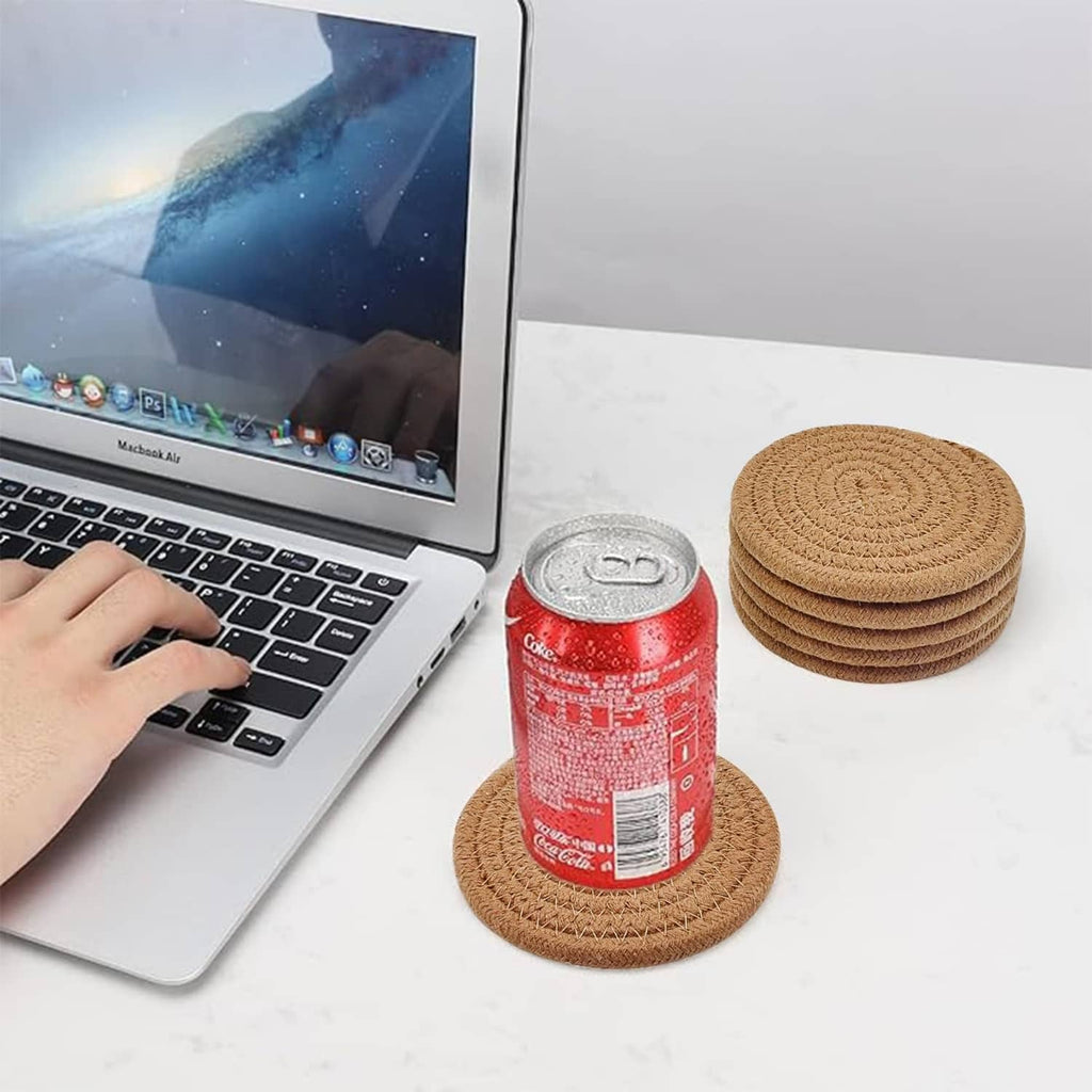 Tan woven round coaster holding a soda can; stack of matching coasters nearby