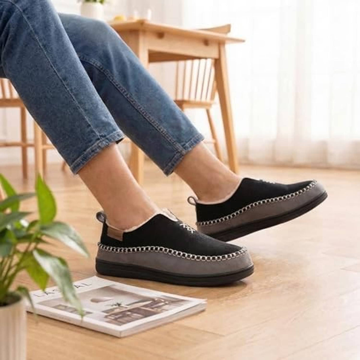 Men's black moccasin slippers worn with chain-trim slip-on design