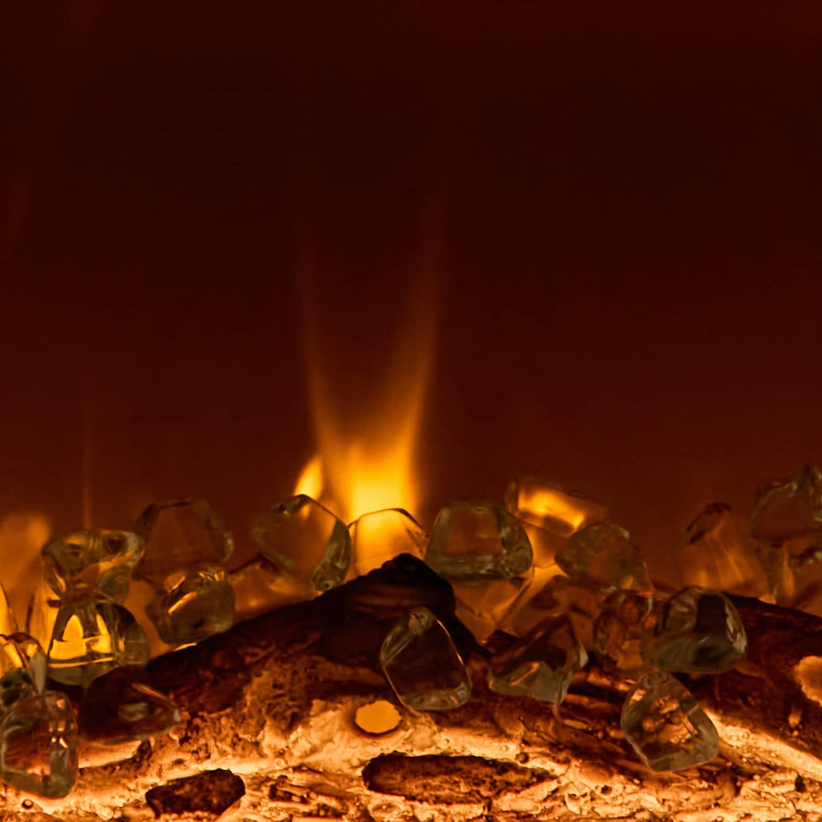 Recessed electric fireplace flame effect over dark logs with glowing embers