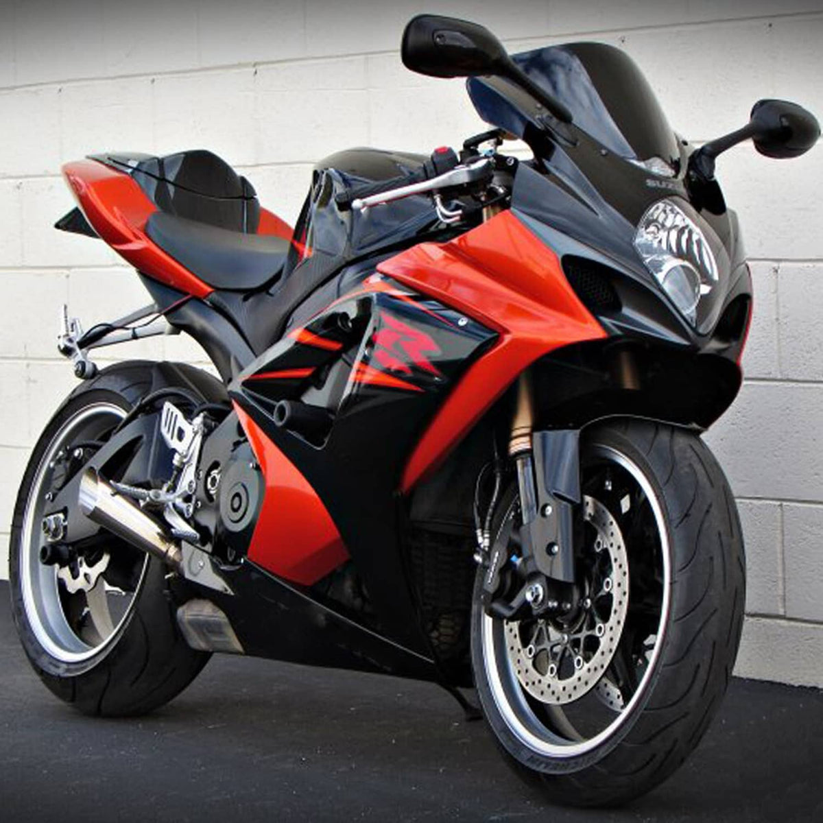 Motorcycle front headlight assembly with clear lens and black housing on sport bike