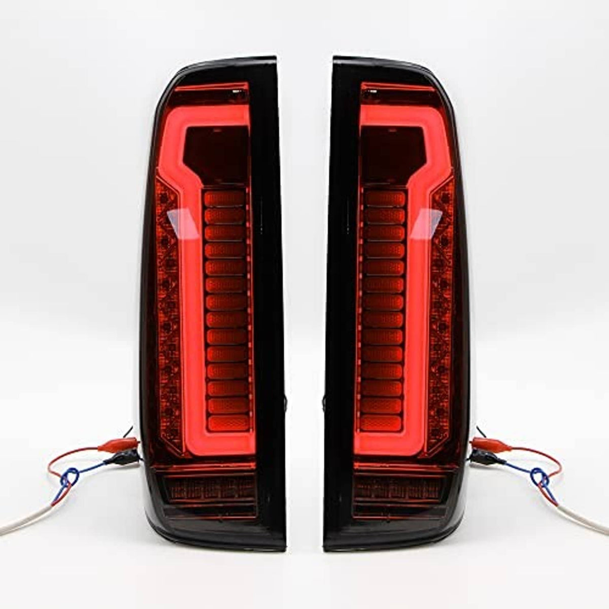 LED tail light assembly pair with red illuminated vertical bars and red outer lenses, black housing