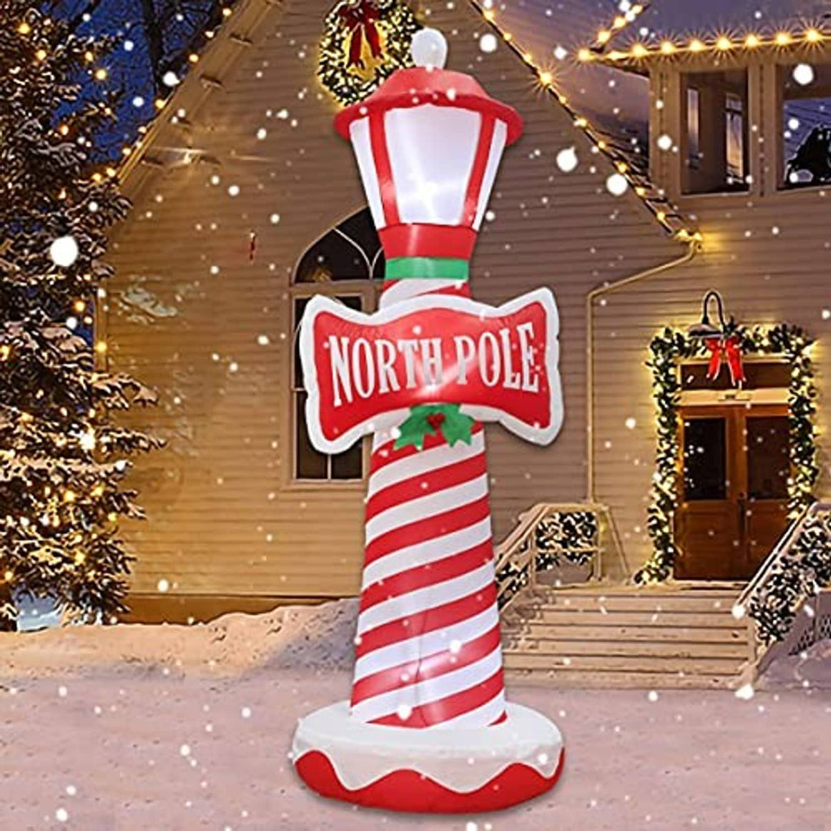Inflatable Christmas lighthouse with illuminated lantern top, candy-cane stripes, North Pole sign