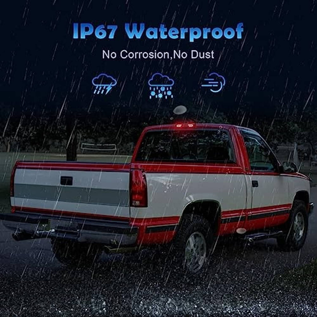 LED third brake light on pickup truck in rain, red lights glowing