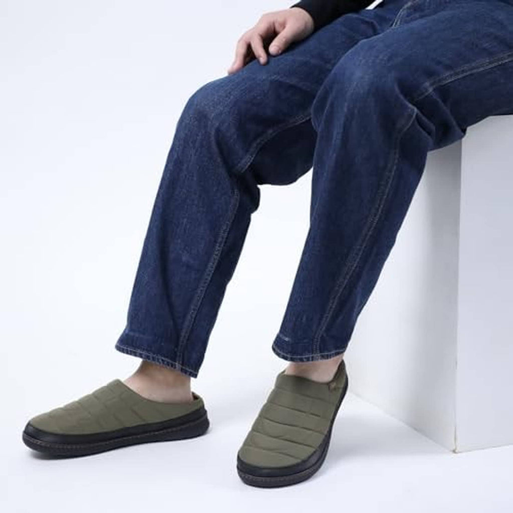 Men's olive green slip-on slippers worn with jeans
