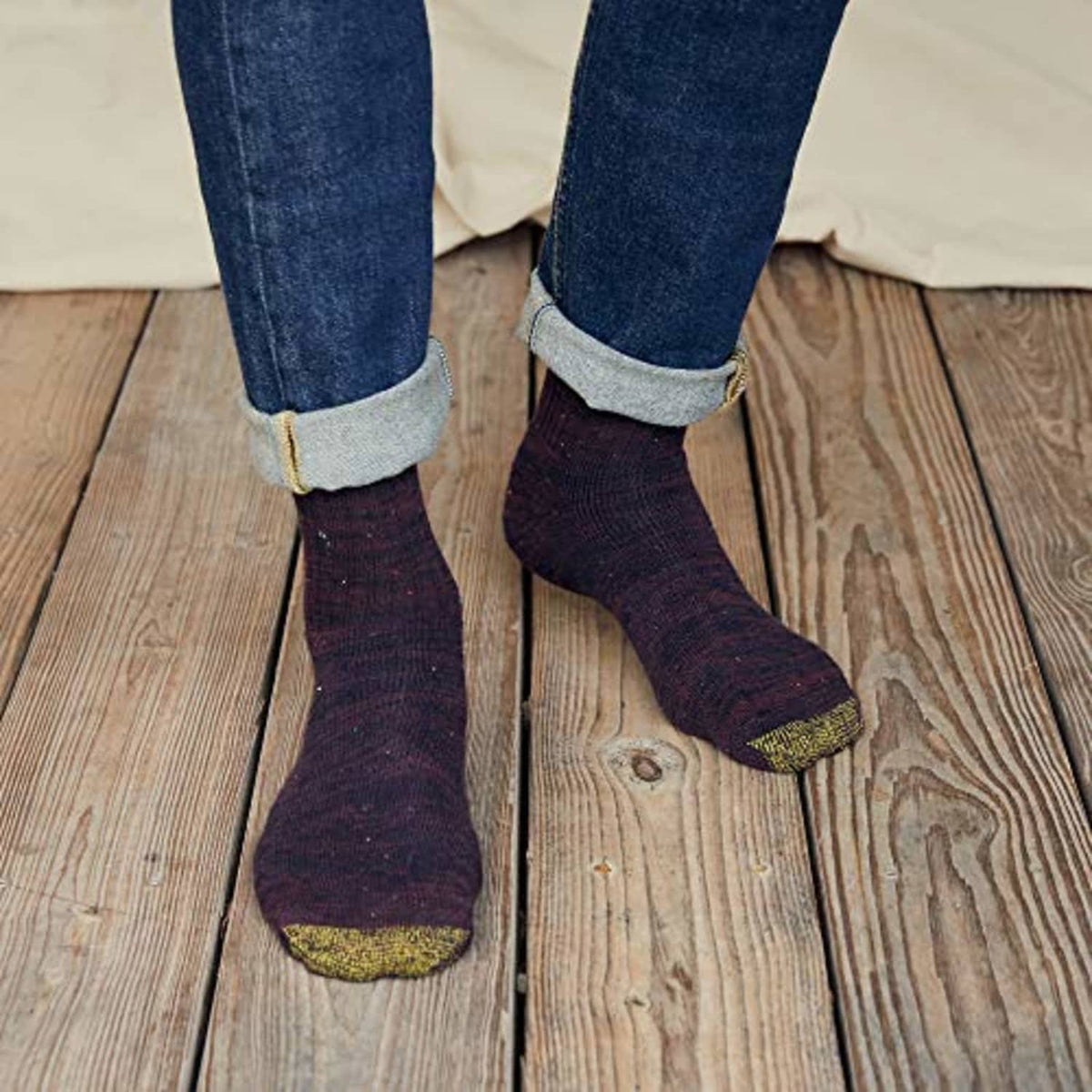 Men's dark crew socks with yellow toe and heel, worn with jeans