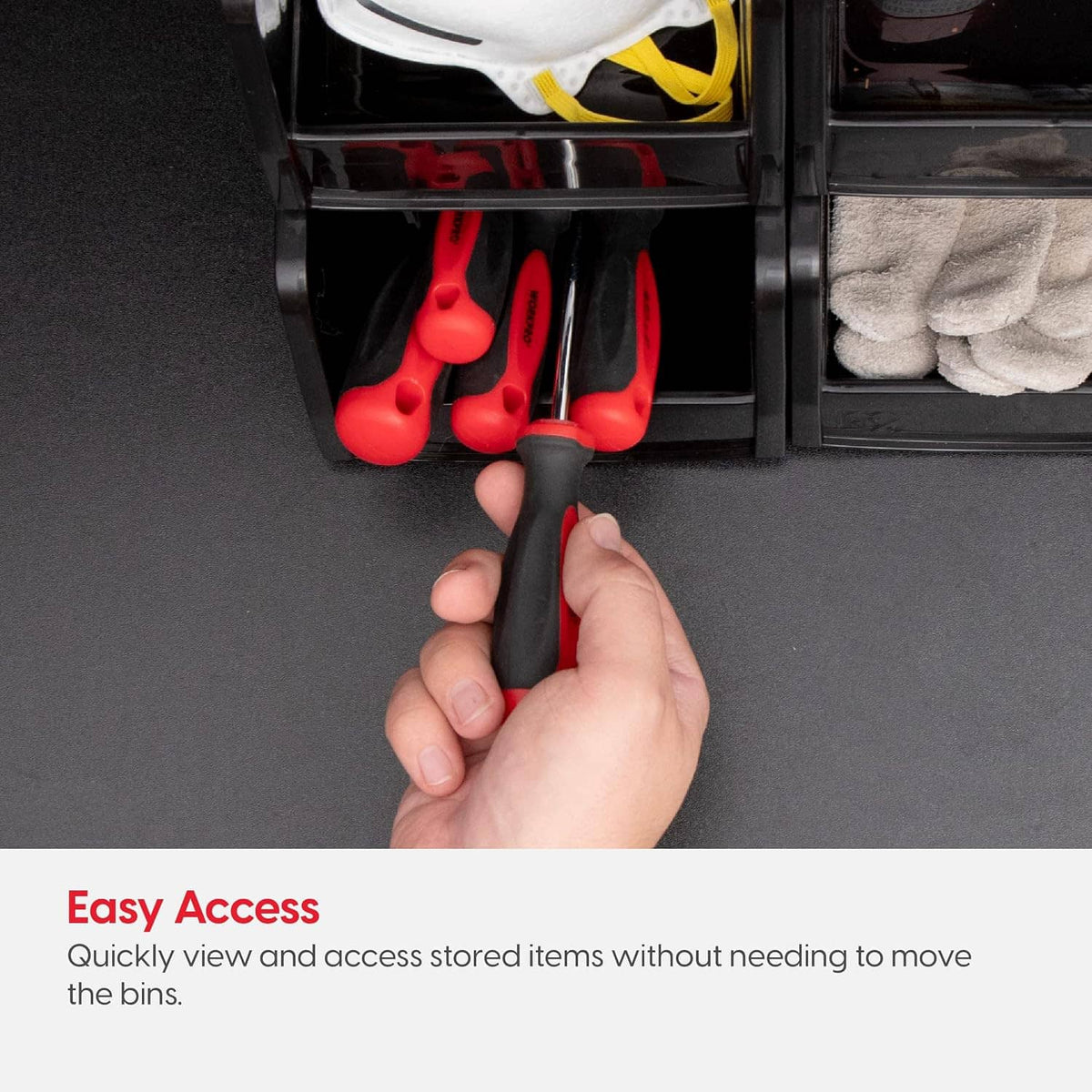 Black storage bin with red hand tools and a hand reaching into the compartment
