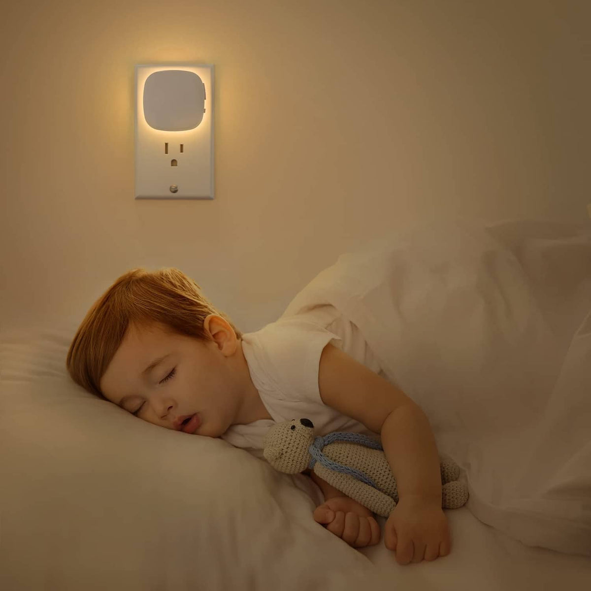Warm white plug-in LED night light on wall above a sleeping child