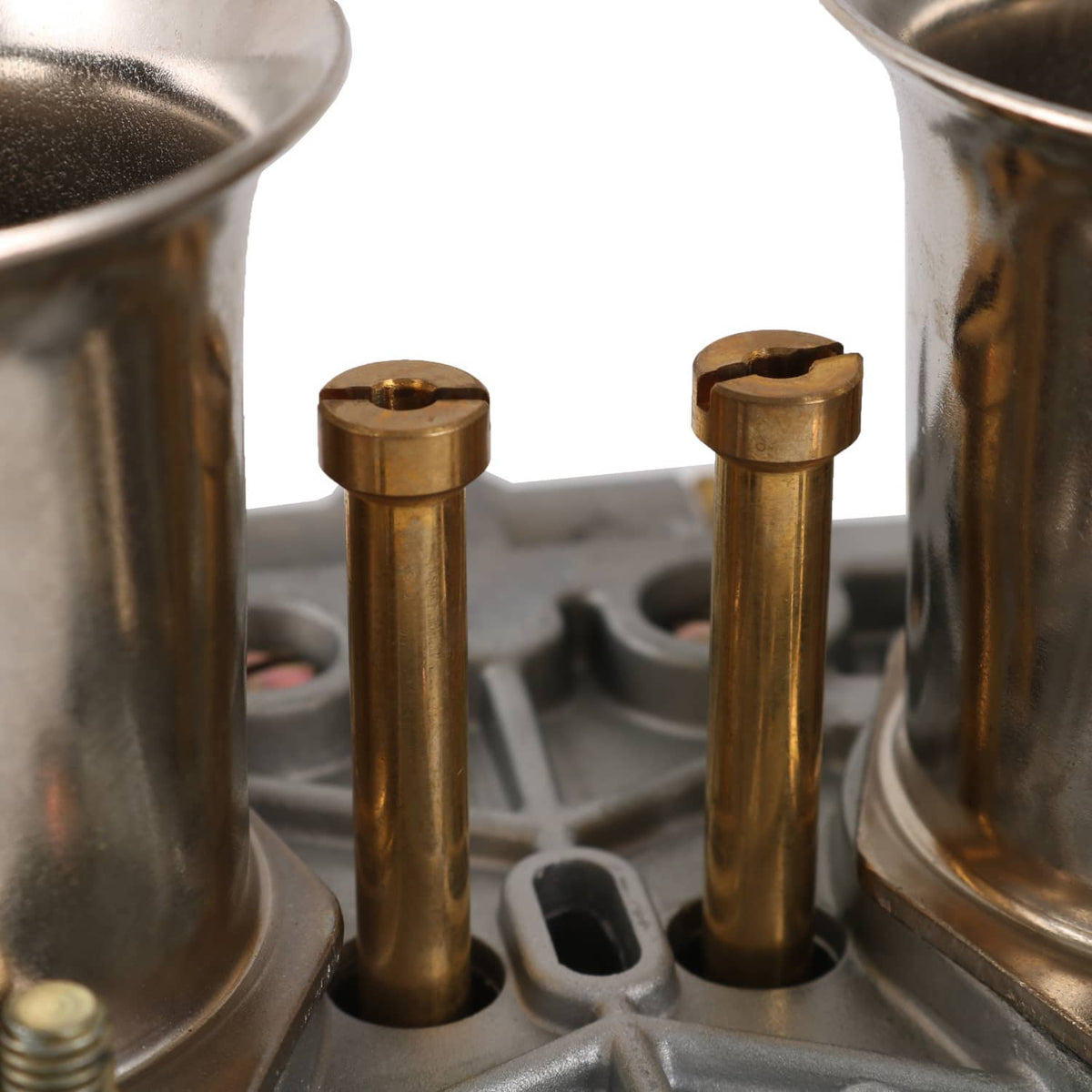 Carburetor kit parts with two brass pins and surrounding metal base plate