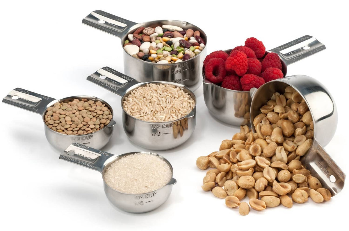 Stainless steel measuring cups holding dry ingredients and fruits