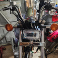 Squared chrome LED headlight with amber turn signals on a motorcycle front